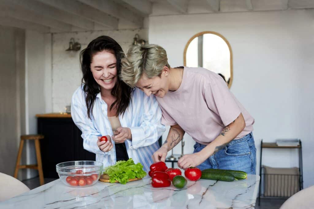 Happy girlfriends preparing a healthy nutrition meal plan by NutriPOM.