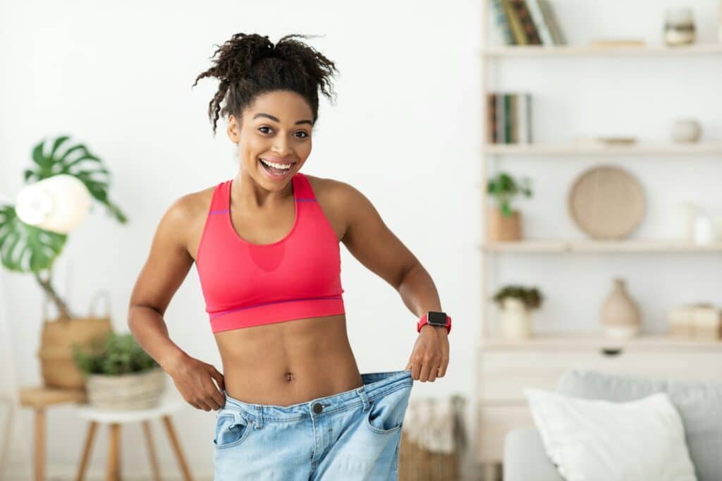 An excited young woman who joined NutriPOM's Metabolic Balance Program to lose weight and is showcasing the results.